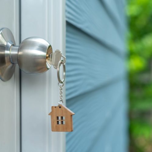Should You Change Locks When Buying a House? Key in the door of a new house.