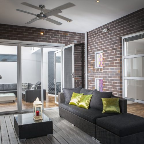 White SupaScreen sliding doors leading to a deck area, with a dark couch.