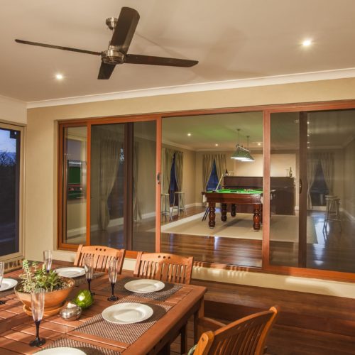 Sliding SupaScreen doors leading to a room with wood table.