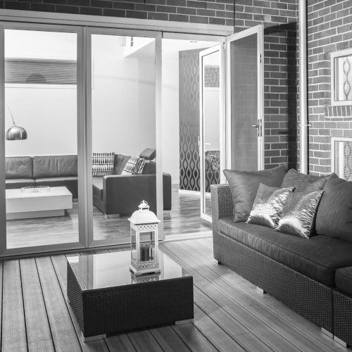 Black and white image of an outdoor patio, seating and security doors.